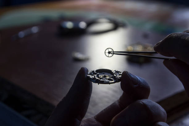 istock A watch maker is repairing a vintage automatic watch. 803435126