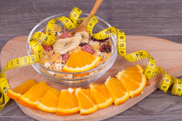 Healthy food on a woody background. Musli and orange are cut into pieces. Diet meal suitable for weight loss and acceleration of metabolism