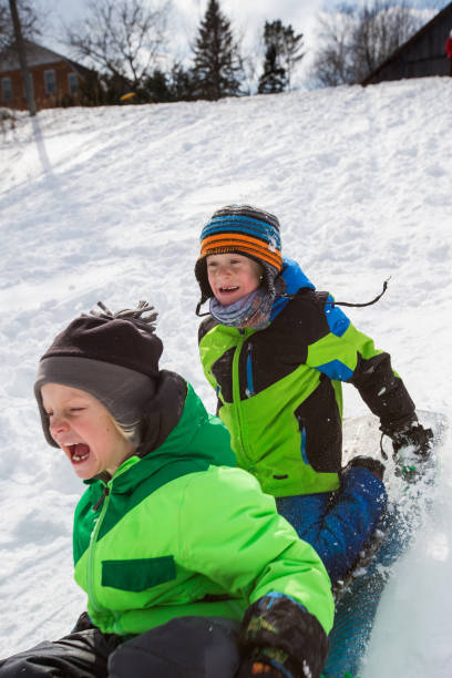 istock Boys riding a sled, tobogganing down the snow 803453936
