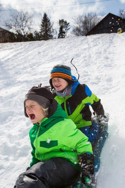 istock Boys riding a sled, tobogganing down the snow 803454140