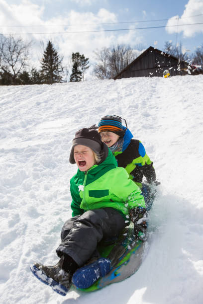 istock Boys riding a sled, tobogganing down the snow 803454424