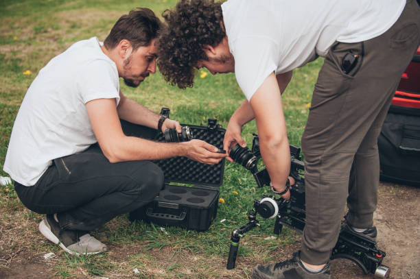 istock Behind the scene. Cameraman and assistant changes lens on camera 803457010
