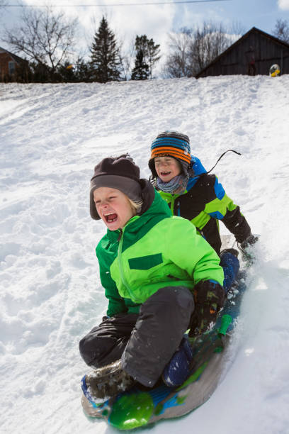 istock Boys riding a sled, tobogganing down the snow 803457112