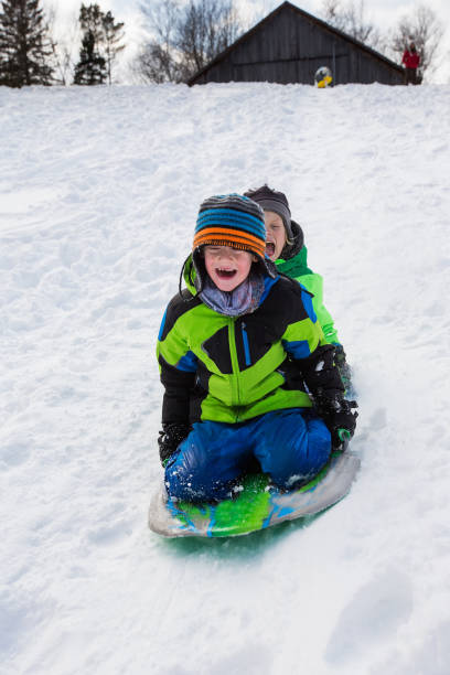 istock Boys riding a sled, tobogganing down the snow 803459278