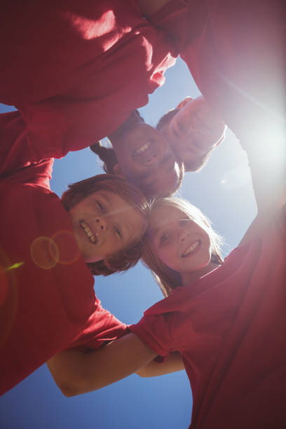 istock Kids forming huddle in the boot camp 803459374