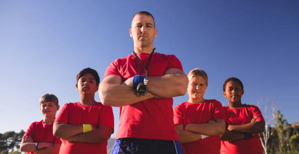 istock Trainer and kids standing together with arms crossed 803459900