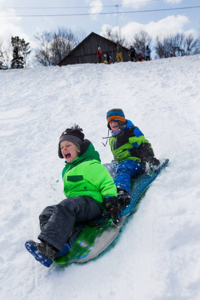 istock Boys riding a sled, tobogganing down the snow 803459926