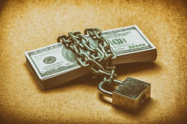 Photo of many dollars is locked with chain, vintage color.