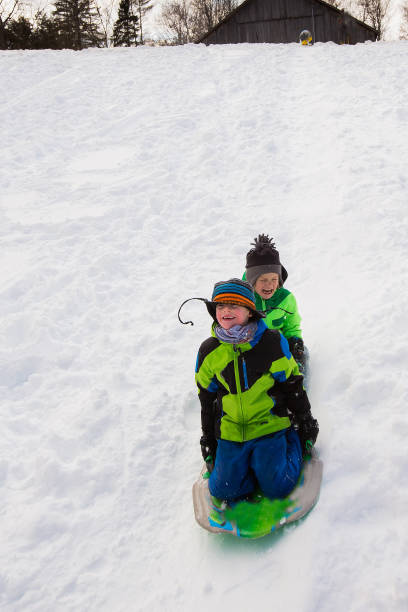 istock Boys riding a sled, tobogganing down the snow 803462168
