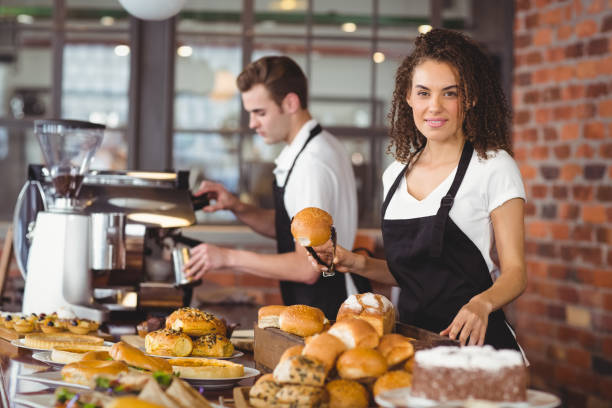 istock Smiling waitress holding bread roll with tong 803474042