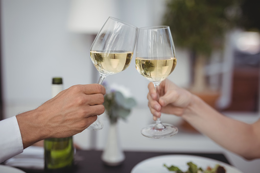 Couple toasting wine glasses in restaurant