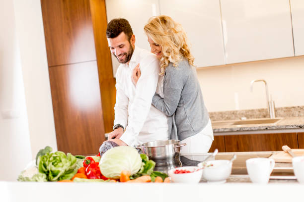 istock Young man helping his girlfriend cooking 803479462