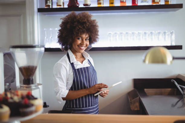 istock Portrait of smiling waitress using digital tablet at counter 803497402