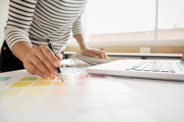 istock Graphic design and color swatches and pens on a desk. Architectural drawing with work tools and accessories. 803506516