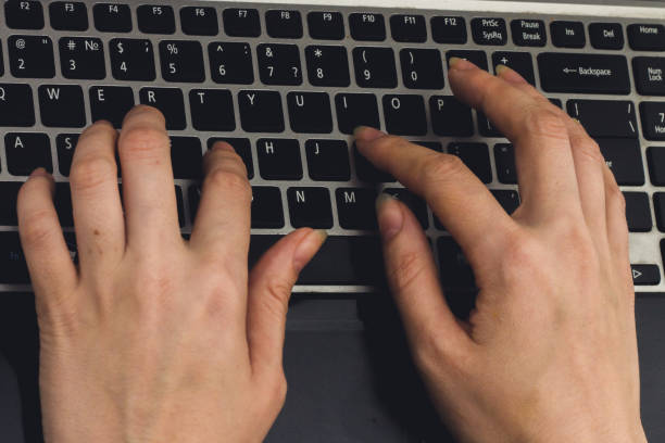 istock Close-up of typing female hands on keyboard 803512776