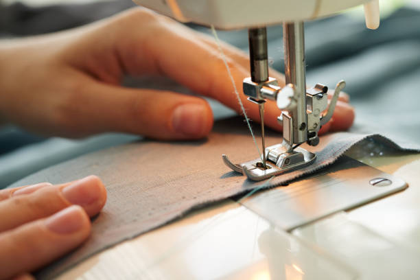 Sewing process Close-up image of tailor sewing on sewing machine clothing design studio photos stock pictures, royalty-free photos & images