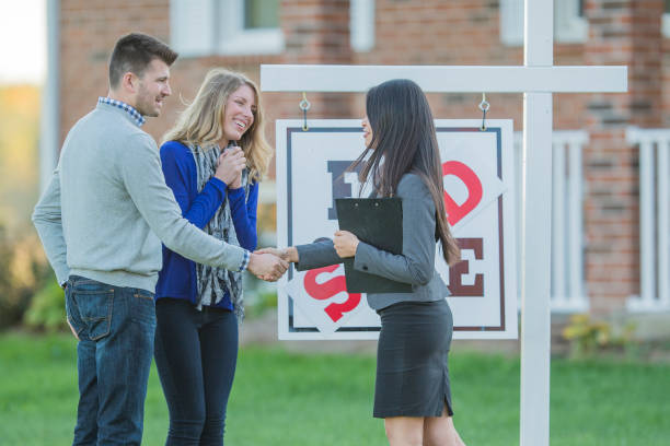 istock Excited Couple Shakes Hands With a Real Estate Agent 803520058