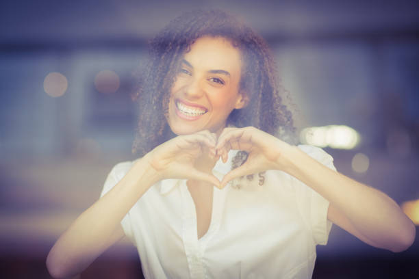 istock Smiling woman making heart shape 803524336