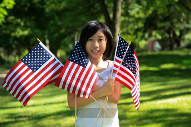 Azjatycka dziewczyna trzymająca amerykańskie flagi – zdjęcie