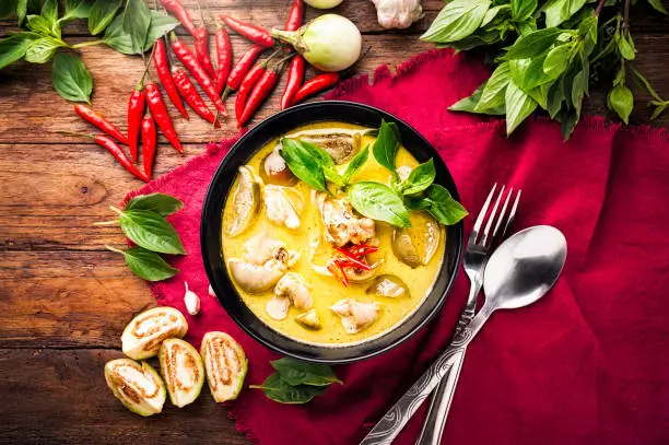 Photo of Thai food green curry chicken on wooden background. top view
