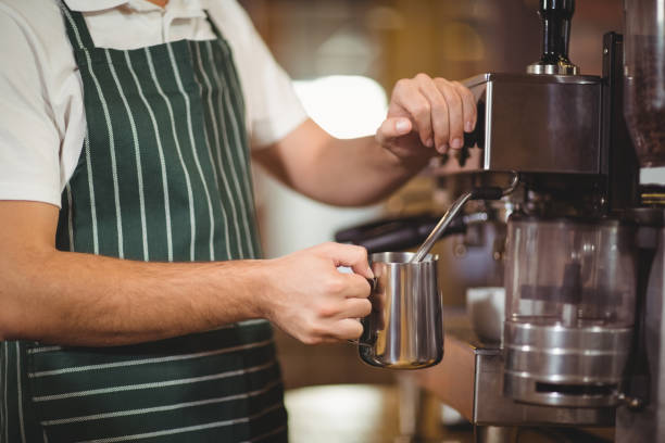 istock Barista steaming milk at the coffee machine 803524824