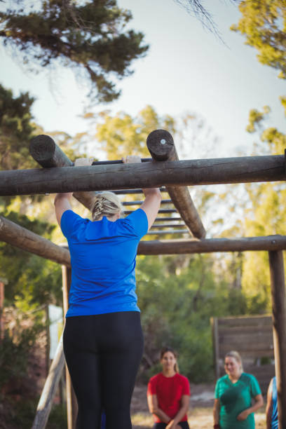 istock Woman climbing monkey bars during obstacle course training in the boot camp 803533774