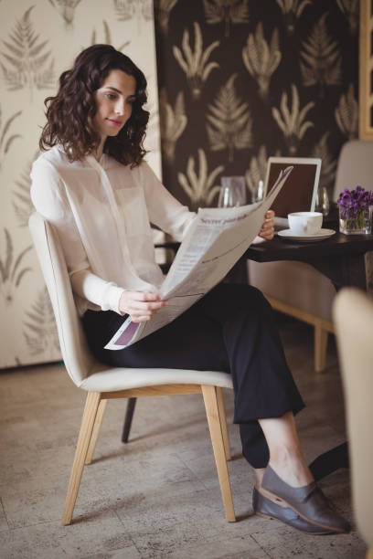 istock Beautiful woman reading newspaper 803540872