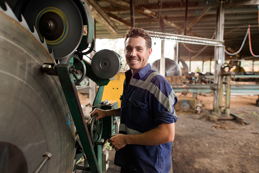 Portrait of a man smiling at camera using machinery