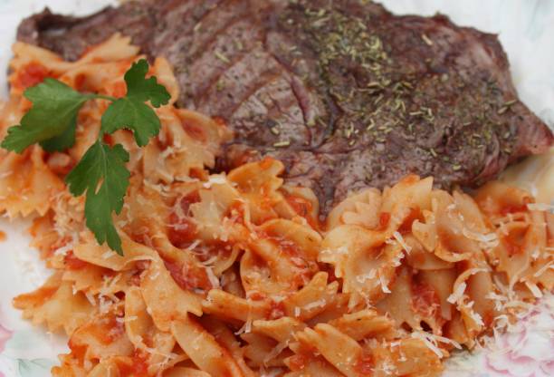 Butterfly pasta "Farfalle" in tomato sauce Butterfly pasta "Farfalle" in tomato sauce - Grilled Beef steak grillade stock pictures, royalty-free photos & images