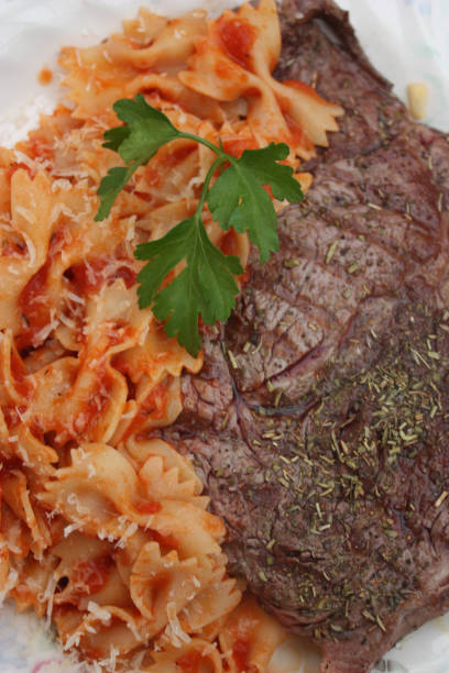 Butterfly pasta "Farfalle" in tomato sauce Butterfly pasta "Farfalle" in tomato sauce - Grilled Beef steak grillade stock pictures, royalty-free photos & images