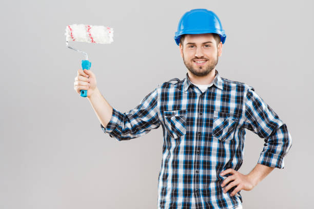 istock Man holding brush for painting walls 803577376