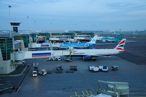 Passenger airplane on the airfield docked with passenger boarding bridge. Preparations of the airplane at the airport terminal.