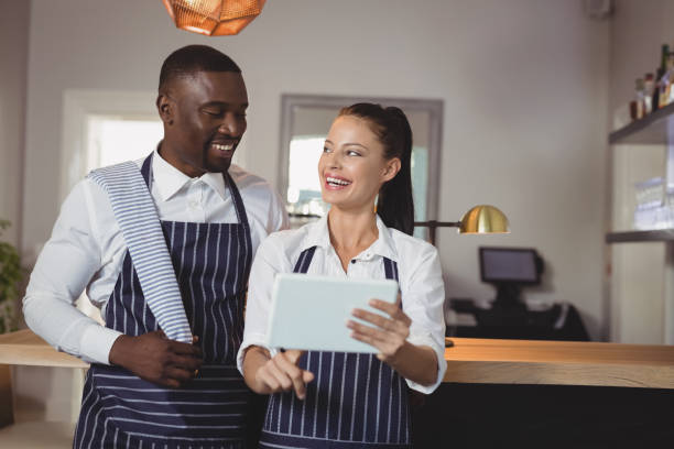 istock Waiter and waitress discussing over digital tablet 803594284