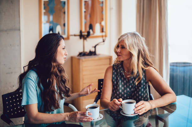 senior mother and daughter drinking coffee together at home - coffee women friendship cafe imagens e fotografias de stock