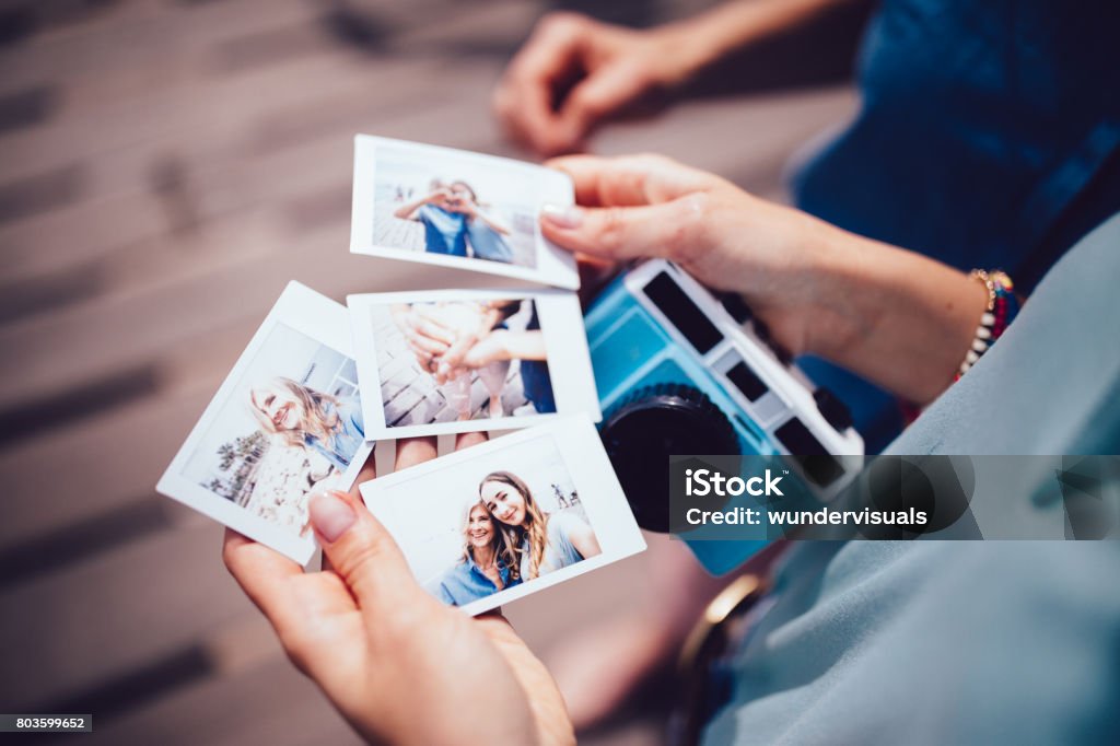 Joven mujer sosteniendo fotos polaroid con mamá en vacaciones de verano - Foto de stock de Cámara de bolsillo libre de derechos
