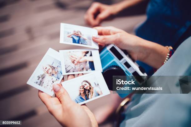Joven Mujer Sosteniendo Fotos Polaroid Con Mamá En Vacaciones De Verano Foto de stock y más banco de imágenes de Cámara de bolsillo