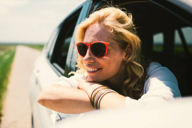 Woman on the road trip. Looking threw the car window.