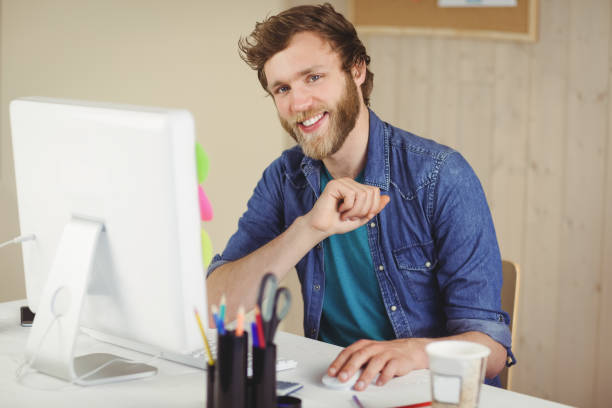 istock Happy hipster working at his desk 803603358