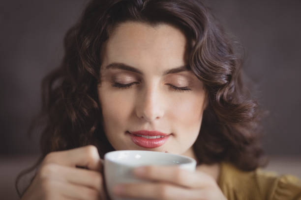istock Woman smelling coffee in restaurant 803609634