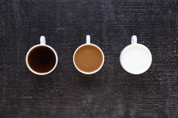 istock Three cups with coffee and milk on black background 803612432