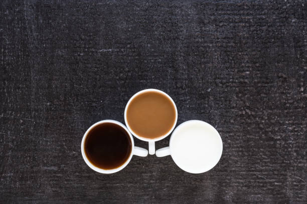 istock Three cups with coffee and milk on black background 803612586
