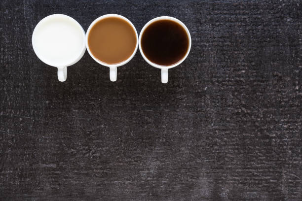 istock Three cups with coffee and milk on black background 803612718
