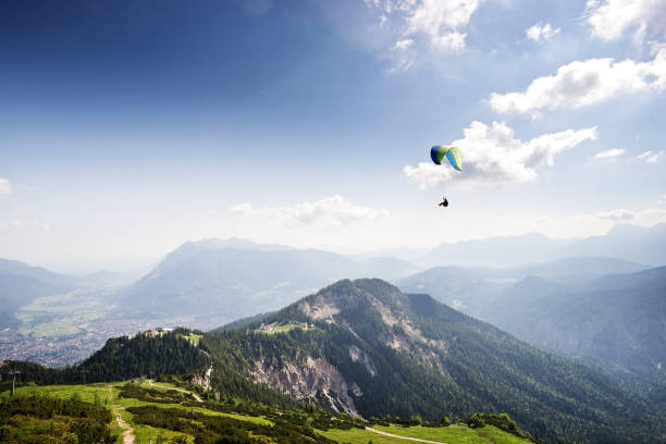 ババリアの館内山の風景の向こうに滑空パラグライダー - wetterstein mountains bavaria mountain forest ストックフォトと画像