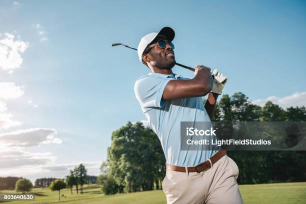 Smiling African American Man In Cap And Sunglasses Playing Golf Stock Photo - Download Image Now