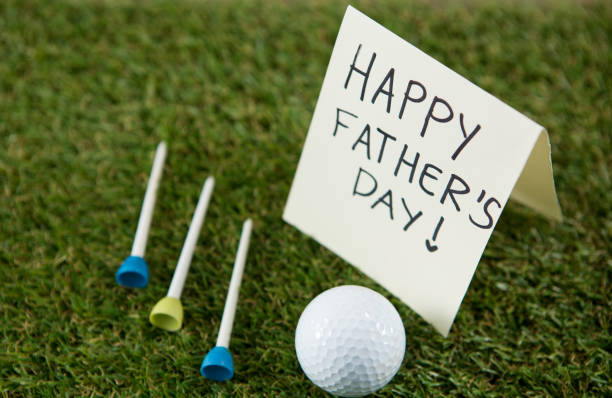 Close up of fathers day message with golf ball and tee on grassy field