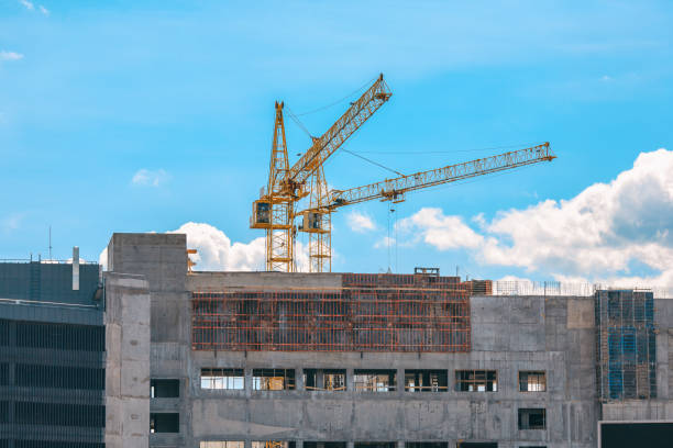 istock Yellow cranes and building under construction against blue sky. 803642976
