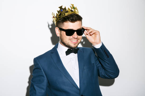 istock Man in crown touching glasses 803643956