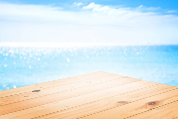 istock wooden table top on blurred beach background for product display. 803658362