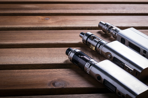 variety of electronic cigarette or e cig over a wooden background.