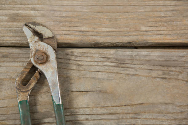 Close up of old metallic pliers on wooden table